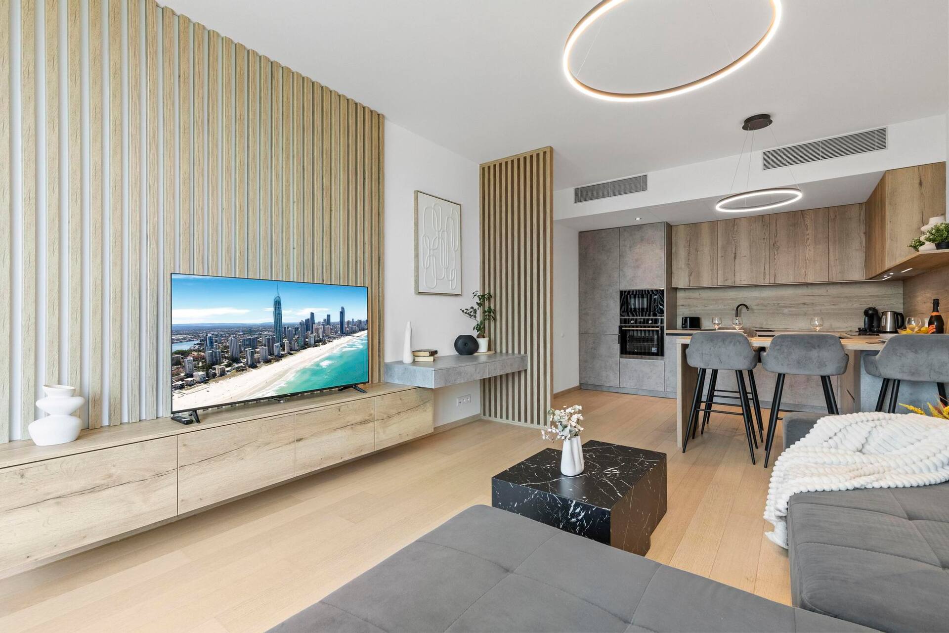 Denná zóna bytu Sky Park Bratislava s drevenou lamelovou stenou
